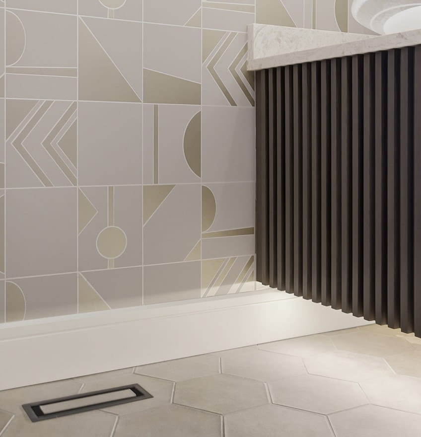 Gray tiled shower with a built-in bench, rolled towel, wooden brush, and green leaves. Chevron pattern tiles add a sleek, modern feel.